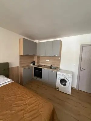 a kitchen with a bed and a washing machine at Sea Side in Burgas City