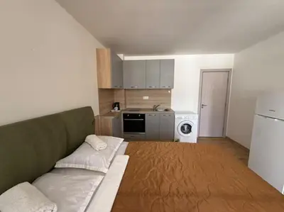 a living room with a couch and a kitchen at Sea Side in Burgas City