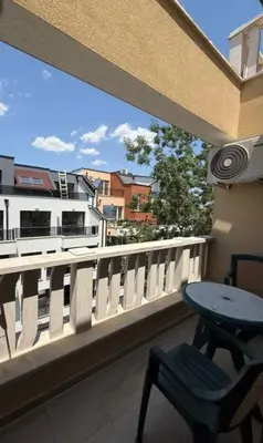 a table and a chair on a balcony with a view at Sea Side in Burgas City