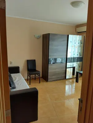 a room with a bed and a chair and a mirror at Отдых in Sunny Beach