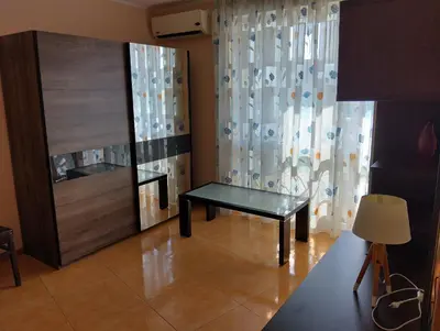 a living room with a table and a mirror at Отдых in Sunny Beach