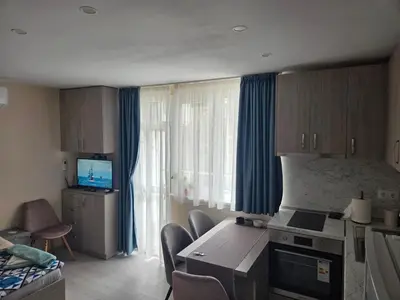 a room with a kitchen with a table and a television at Апартамент 9 -Рилска in Burgas City