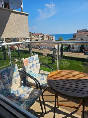 a table and two chairs on a balcony with a table at 2BR Sea Sunrise View Apartment Happy Place in Chernomorets