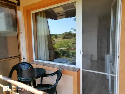 a balcony with a table and chairs and a window at Вила Фернандес in Chernomorets