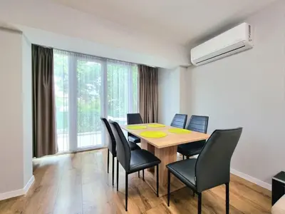 a dining room with a wooden table and chairs at Relax & Spa-House near Therma Numera in Burgas City