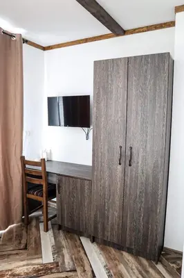 a wooden cabinet in a room with a desk at Конакъ Войнов in Yasna Polyana