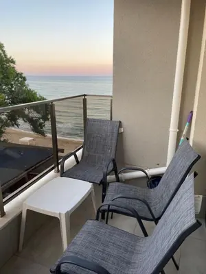 two chairs and a table on a balcony with the ocean at Apartment Bela in Obzor