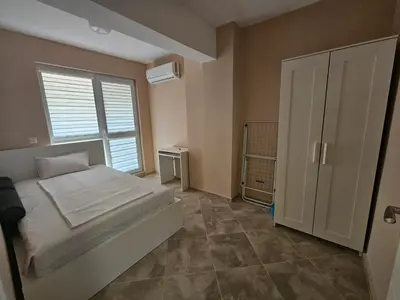 a bedroom with a bed and a large window at Апартаменти Кастро2-Castro Apartments2 in Tsarevo