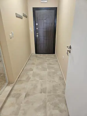 a hallway with a door and a tiled floor at Апартаменти Кастро2-Castro Apartments2 in Tsarevo