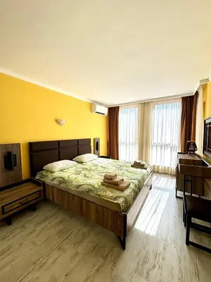 a bedroom with a large bed and a desk at Royal Dreams apartments - 2 in Sunny Beach