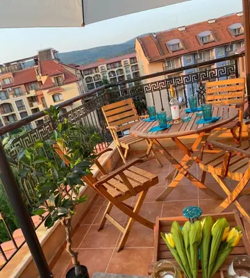 a patio with a table and chairs on a balcony at Kasandra Apart Hotel in Sunny Beach