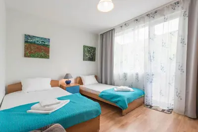a bedroom with two beds and a window at Aristocratic to the Sea Garden in Varna City