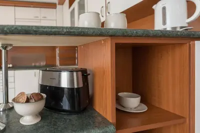 a kitchen with a coffee maker and bowls on a counter at Aristocratic to the Sea Garden in Varna City