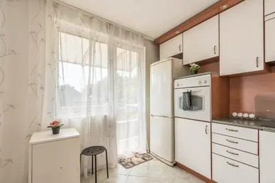 a kitchen with a white refrigerator and a window at Aristocratic to the Sea Garden in Varna City