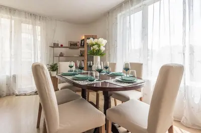 a dining room with a table with white chairs at Aristocratic to the Sea Garden in Varna City