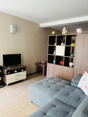 a living room with a couch and a tv at GREEN PARADISE apartments in Sveti Vlas