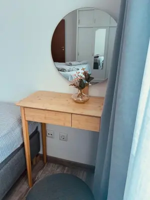 a bedroom with a table with a mirror and a bed at Green Paradise apartments in Sveti Vlas