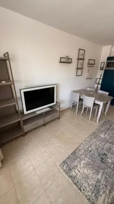 a living room with a tv and a table with chairs at Apartment Zornitsa I Panoramic Sea View in Sozopol