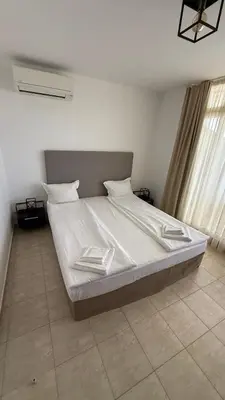 a bed with white sheets and pillows in a bedroom at Apartment Zornitsa I Panoramic Sea View in Sozopol