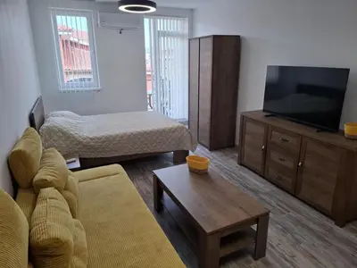 a living room with a couch and a flat screen tv at РАВДА Лазур Аурелия in Ravda