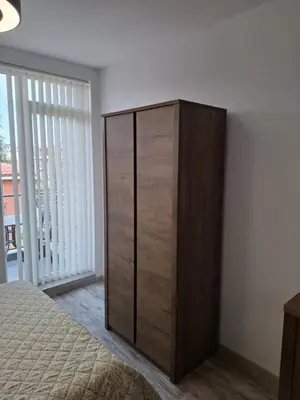a large wooden cabinet in a room with a bed at РАВДА Лазур Аурелия in Ravda