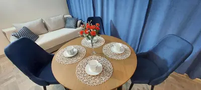 a wooden table with blue chairs and a couch at Ela, Kedar 3 in Sveti Vlas