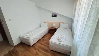 two beds in a small room with white curtains at ATOS 507 Studio Sunny Beach in Sunny Beach