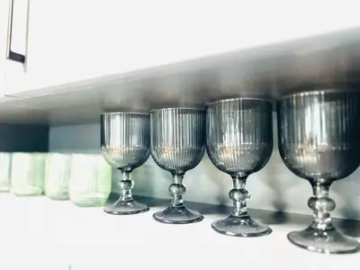 a row of wine glasses sitting on a shelf at Heart of City, Steps to Beach in Burgas City