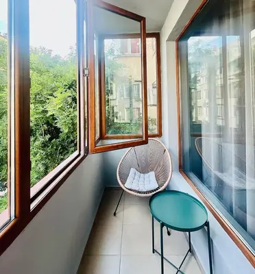a small balcony with a chair and a table at Heart of City, Steps to Beach in Burgas City
