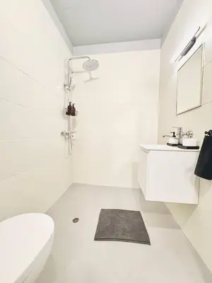 a white bathroom with a toilet and a sink at Heart of City, Steps to Beach in Burgas City