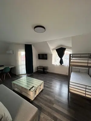 a living room with two beds and a glass table at Апартаменти Лилия 2 in Primorsko
