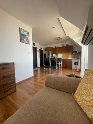 a living room with a couch and a kitchen at Raduga SP apartments St Vlas in Sunny Beach