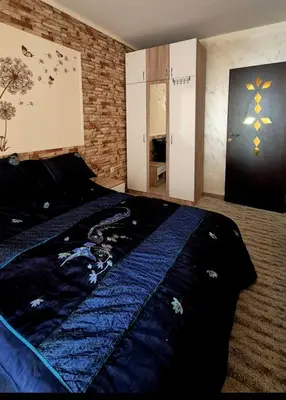 a bedroom with a bed with a blue comforter at White Cliffs первая линия in Byala
