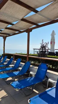 a row of blue chairs sitting on a roof at White Cliffs первая линия in Byala