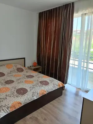 a bedroom with a bed and a large window at Апартаменты за гости Гавань in Byala