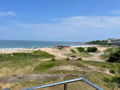 a view of a beach with people and the ocean at First Line Lozenez Beach Anron in Lozenets