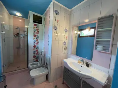 a bathroom with a toilet and a sink and a shower at First Line Lozenez Beach Anron in Lozenets