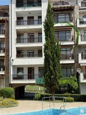 an apartment building with a tree and a swimming pool at Vineyards Resort, Aheloy - Studio 32 in Pomorie