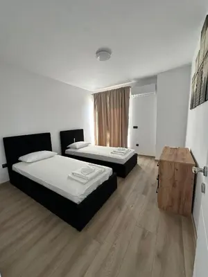 a bedroom with two beds and a wooden floor at Sozopol Beach Apartments in Sozopol