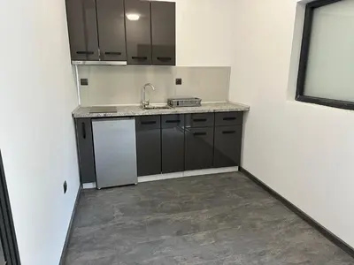 a kitchen with black cabinets and a sink at Sozopol Beach Apartments in Sozopol