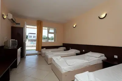 a room with four beds and a tv and a window at ВС Морски дюни in Shkorpilovtsi