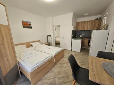 a small bedroom with a bed and a kitchen at Студио Морелия in Tsarevo