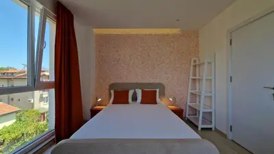 a bedroom with a bed and a large window at Геновева in Kiten