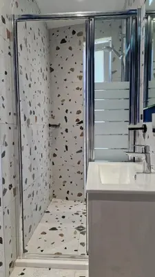 a bathroom with a shower and a white sink at Геновева in Kiten