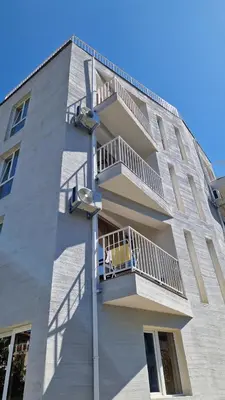 a building with a dog sitting on a balcony at Геновева in Kiten