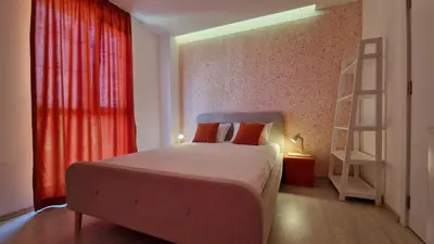a bedroom with a bed with red curtains and a ladder at Геновева in Kiten