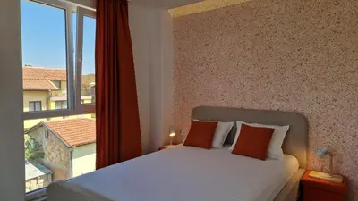 a bedroom with a bed and a large window at Геновева in Kiten