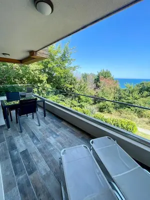 a balcony with chairs and a table and a view at Byla Sea side Apartament in Byala