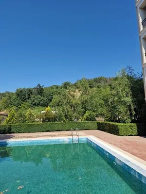 a swimming pool in front of a house with a mountain at Villa Astoria 2 - Premium Apartments in Elenite