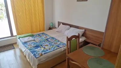 a bedroom with a bed and a table and a table and chairs at One bedroom studio in Chernomorets